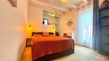 A bedroom with a bed, bedside tables, a mirror, and a window.