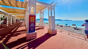 A beachside pavilion with a clear view of the sea, a poster advertising a jazz festival, and a person in the distance. - 3-minute walk to the beach, private villa, garden, parking, tram (Nice)