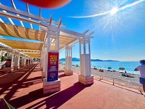 A beachside pavilion with a clear view of the sea, a poster advertising a jazz festival, and a person in the distance. - 3-minute walk to the beach, private villa, garden, parking, tram (Nice)