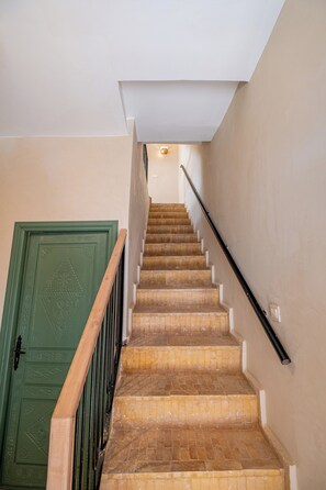 A staircase with wooden steps and a green door at the bottom. - Spacious 6-bedroom riad in charming Marrakesh with A/C (Marrakesh)