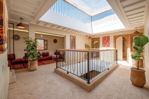 A spacious atrium with a high ceiling, a central open area with a railing, and a view of the sky through the ceiling. - Spacious 6-bedroom riad in charming Marrakesh with A/C (Marrakesh)