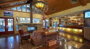 A spacious lobby with a stone fireplace, a bar area, and a seating area with a patterned sofa and chairs. - Celebrate Labor Day weekend in the Missouri Ozarks in this cabin for 6 guests. (Ridgedale)