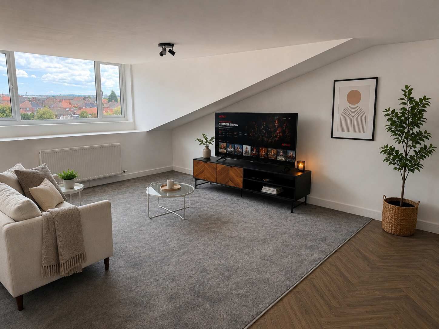 Ein modernes Wohnzimmer mit einer Couch, einem Couchtisch, einem Fernseher und einer Topfpflanze.