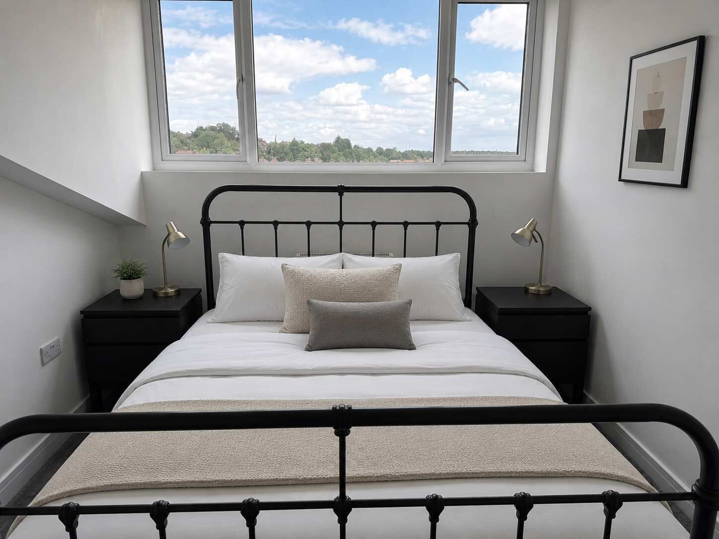 Una camera da letto con un letto, due comodini, una finestra e un quadro appeso al muro.