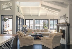 A spacious living room with a high ceiling, large windows, and a fireplace. - Beach House/Rare Rooftop Deck/9 Homes from sand/few blocks to Down Town (Manhattan Beach)