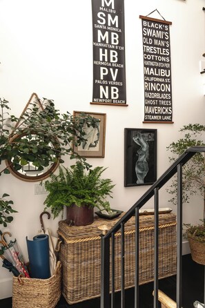 A staircase with wicker baskets, a framed artwork, and two black signs with white text. - Beach House/Rare Rooftop Deck/9 Homes from sand/few blocks to Down Town (Manhattan Beach)