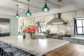 A modern kitchen with a marble countertop, stainless steel appliances, and a central island with seating. - Beach House/Rare Rooftop Deck/9 Homes from sand/few blocks to Down Town (Manhattan Beach)