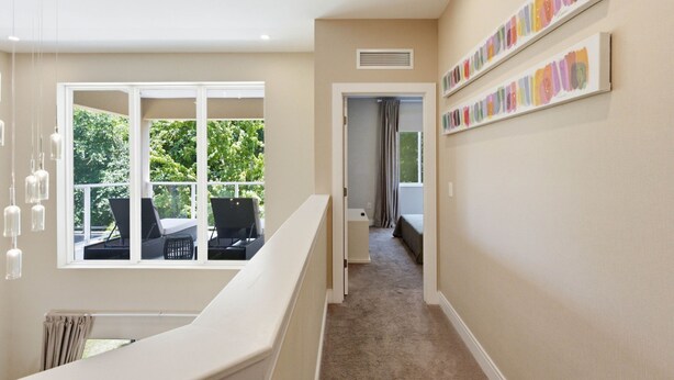 Corredor com vista para móveis de exterior, escadas e uma parede com paleta de cores.