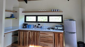 Een moderne keuken met houten kastjes, een vast eiland en een roestvrijstalen koelkast.