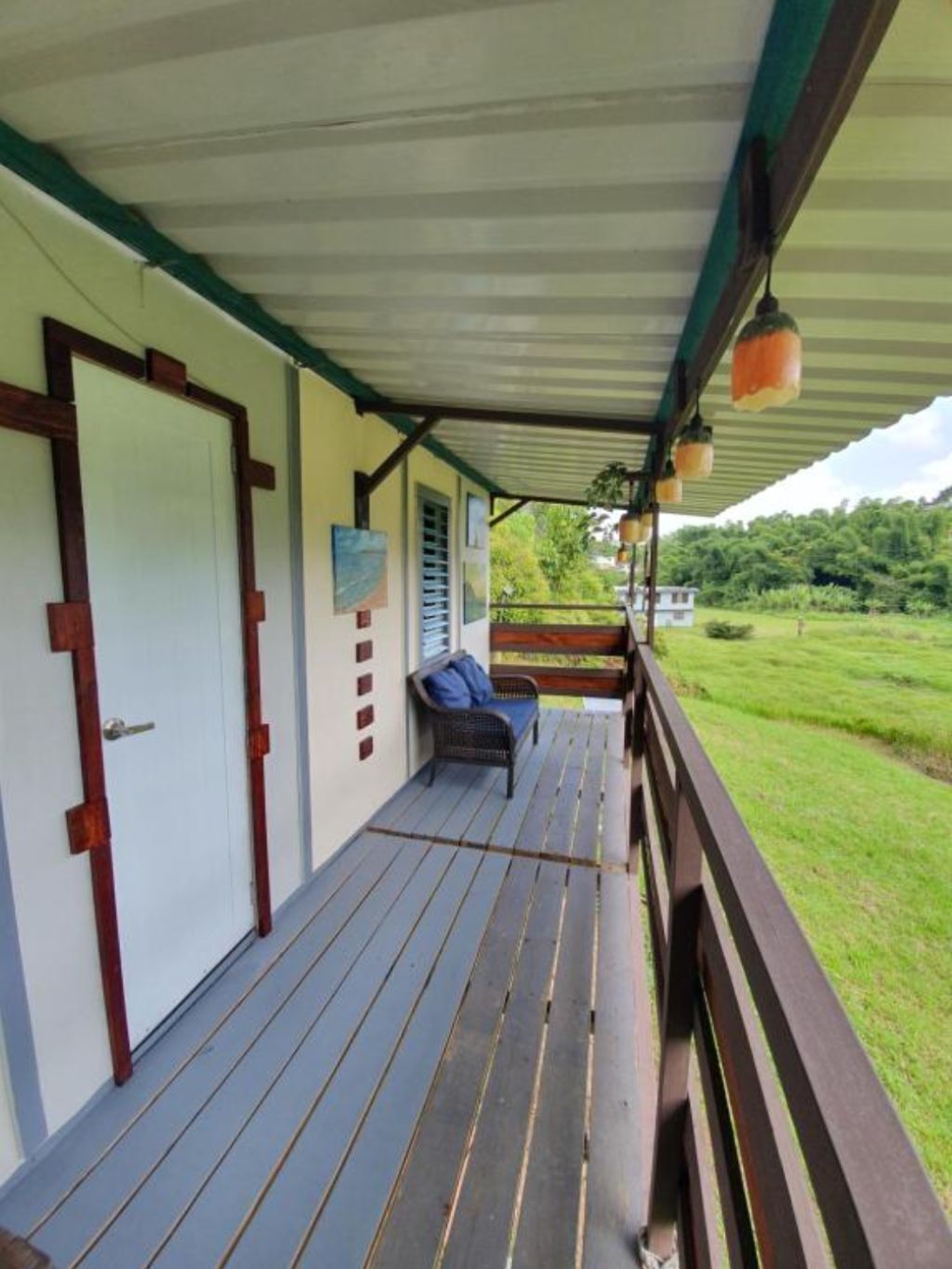 A covered porch with a wooden bench and a door.