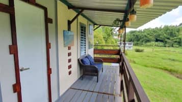 A covered porch with a wooden bench and a door.
