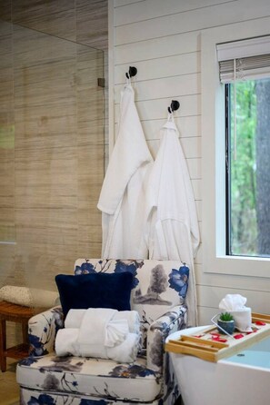 A bathroom with a bathtub, towels, and a window. - Hot Tub, Soaking Tub & Fireplaces | King Suite (Broken Bow)