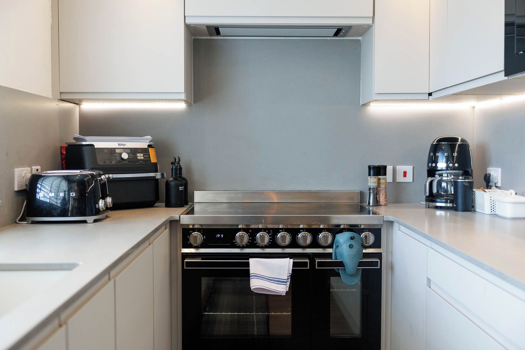 A modern kitchen with a stainless steel stove, a coffee maker, and a toaster.