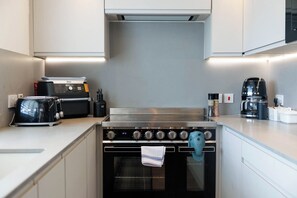 A modern kitchen with a stainless steel stove, a coffee maker, and a toaster.