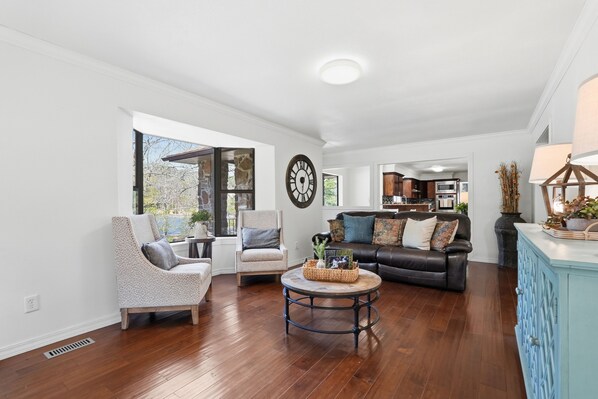 A spacious living room with a fireplace, a dining area, and a kitchen.