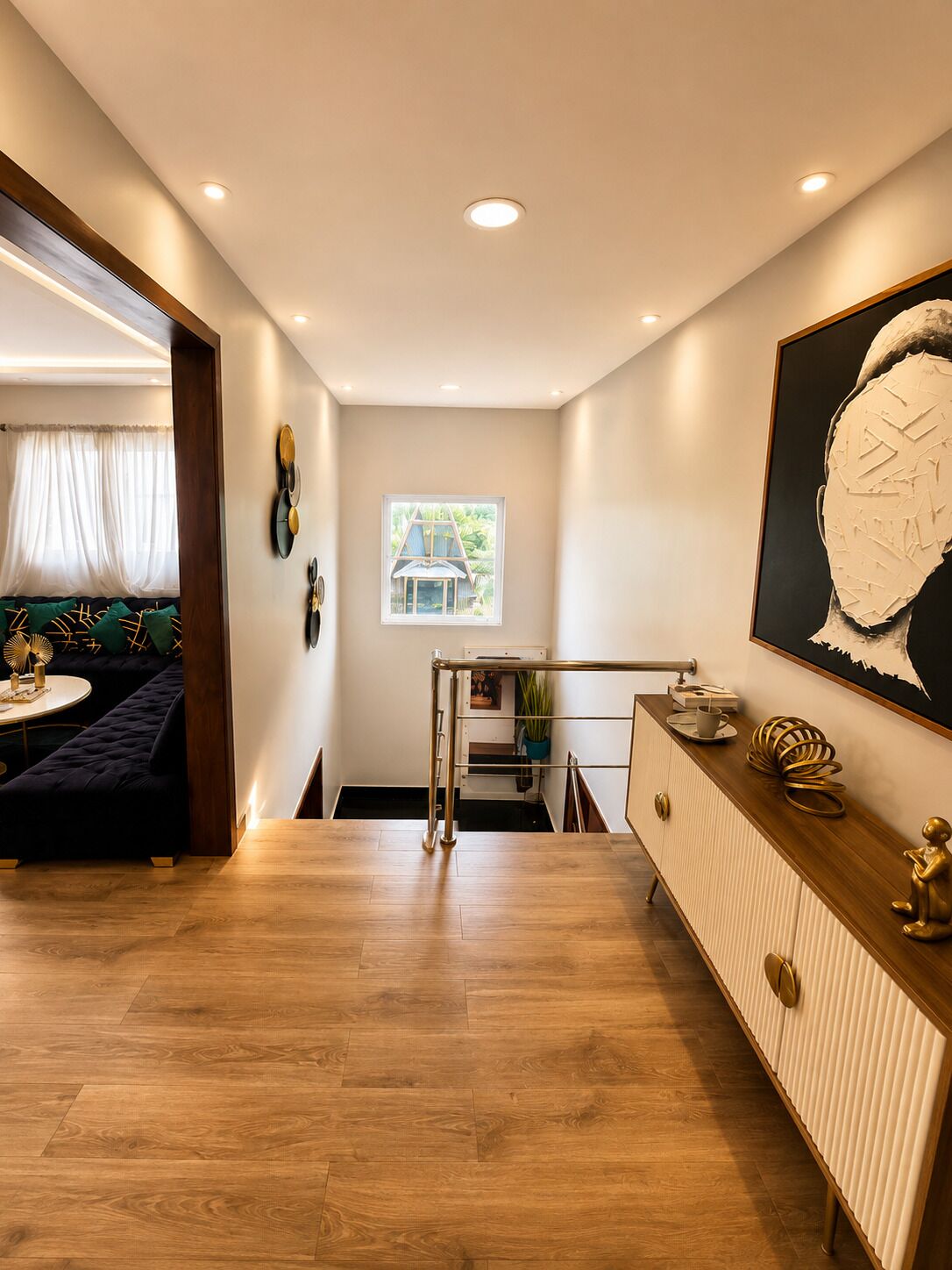 Een modern interieur met een houten vloer, een bank, een eettafel en een trap met een leuning.