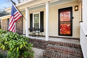A house with a porch, a flag, and a door with a window. - Delightful 3-bedroom house in charming Charleston (Charleston)