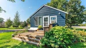 A small house with a front porch, a covered entryway, and a well-maintained lawn.