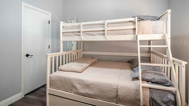 A bunk bed with a lower bunk and a door to the left. - 5BR Pool House + Billiards · Up to 15 Guests (Las Vegas)