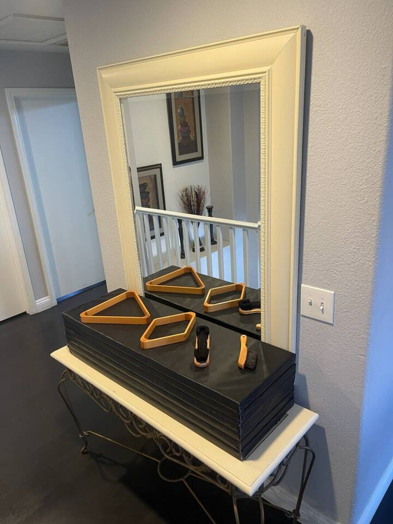 Un meuble-lavabo pour la salle de bain doté d’un grand miroir, d’un plan de travail noir et d’une base blanche.