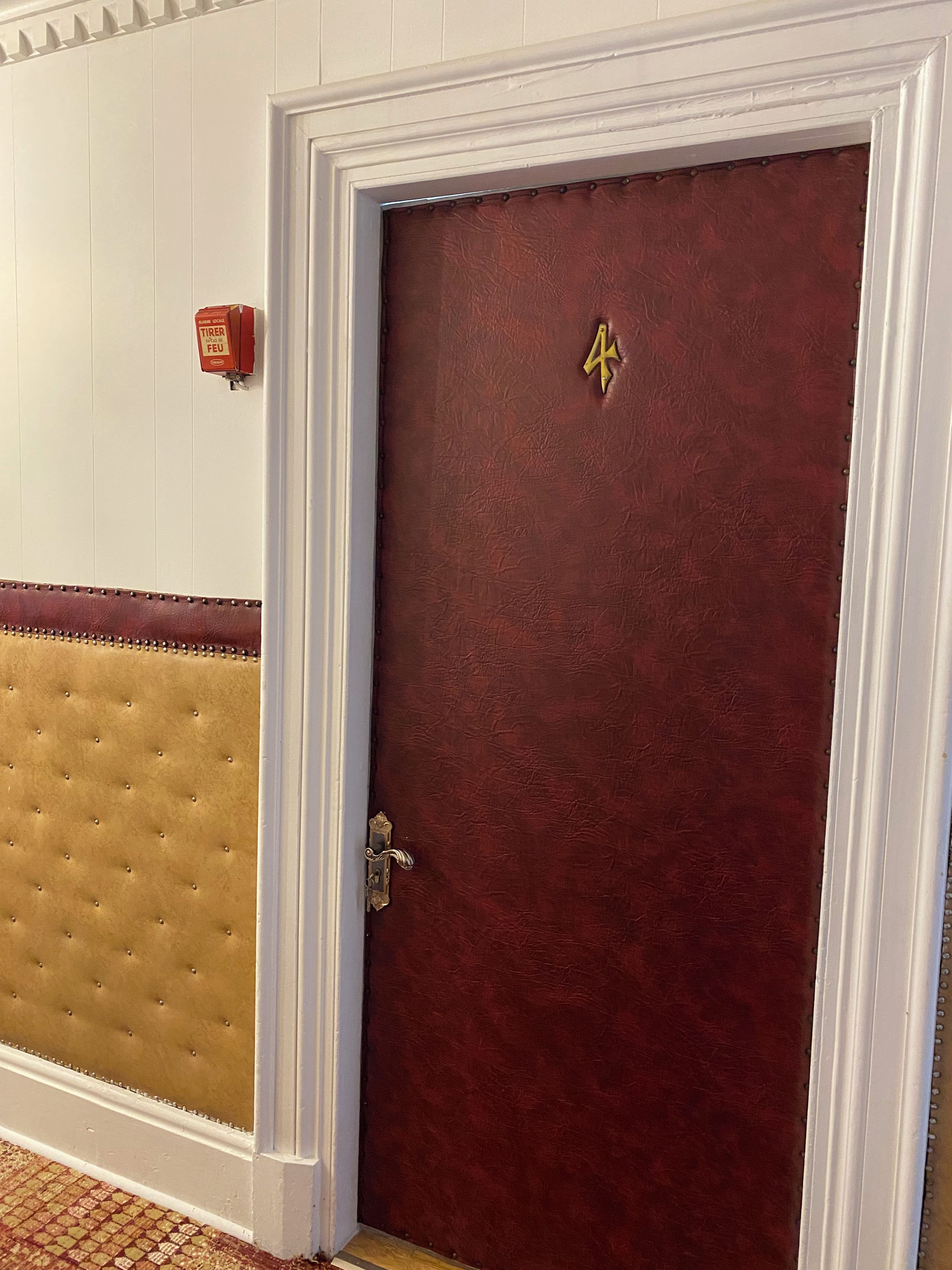 A closed door with a brass handle and a number '4' sign above it.