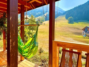 A wooden deck with a hammock and a view of a mountain landscape. - Chalet de la Garde - Alpe d'Huez Resort (La Garde)