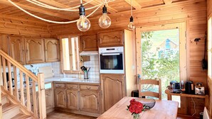 A wooden cabin interior with a kitchen, dining area, and a staircase. - Chalet de la Garde - Alpe d'Huez Resort (La Garde)