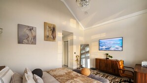 Een moderne slaapkamer met een groot bed, een bureau en uitzicht op de oceaan.