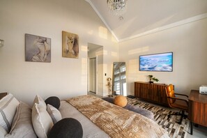 Ein modernes Schlafzimmer mit einem großen Bett, einem Schreibtisch und Blick auf den Ozean.