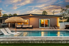 A modern house with a swimming pool, a barbecue area, and a patio with lounge chairs. - The '59 Flamingo | Pool, Hot Tub & Cold Plunge (Apollo Beach)