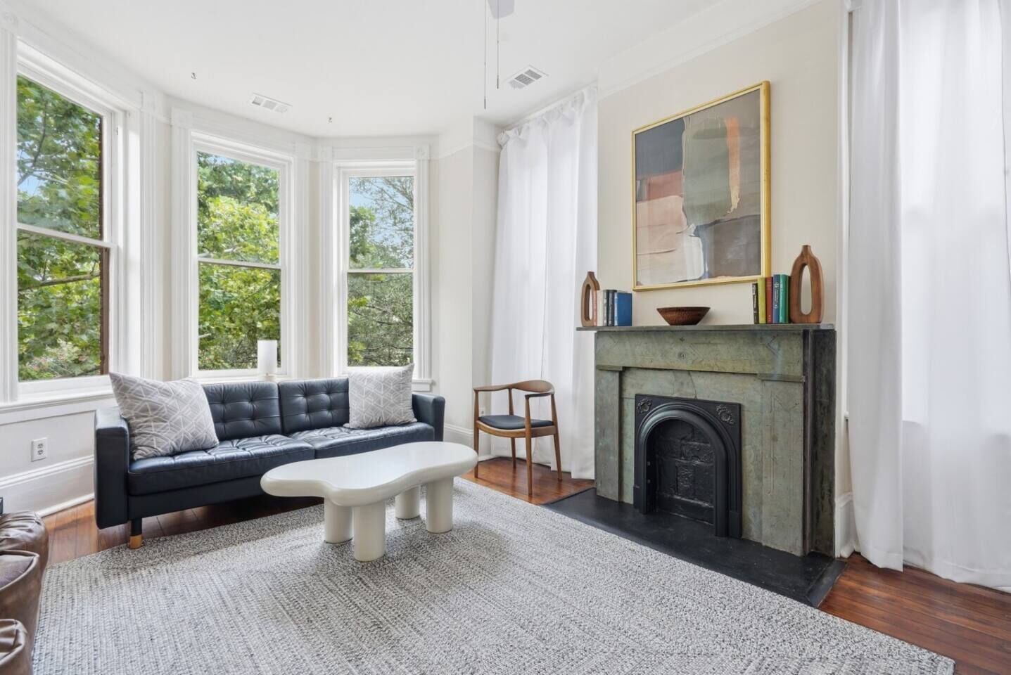 A living room with a fireplace, a sofa, a coffee table, and a chair.