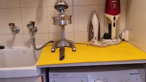 Ein kleiner Waschbereich mit Waschmaschine, Trockner und Durchlauferhitzer.