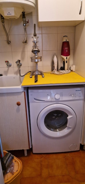 A compact laundry area with a washing machine, a drying machine, and a water heater. - La Ampolla by the Sea (L'Ampolla)