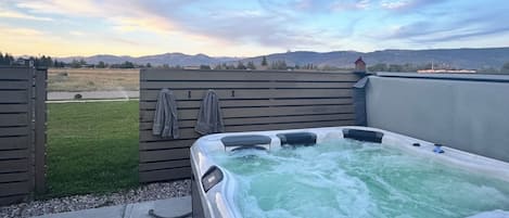 A hot tub with a view of mountains in the background.