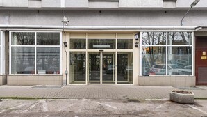 A building with a glass entrance, a tiled ground floor, and a visible fire hydrant. - 2-bed Home on Krochmalna (Warsaw)