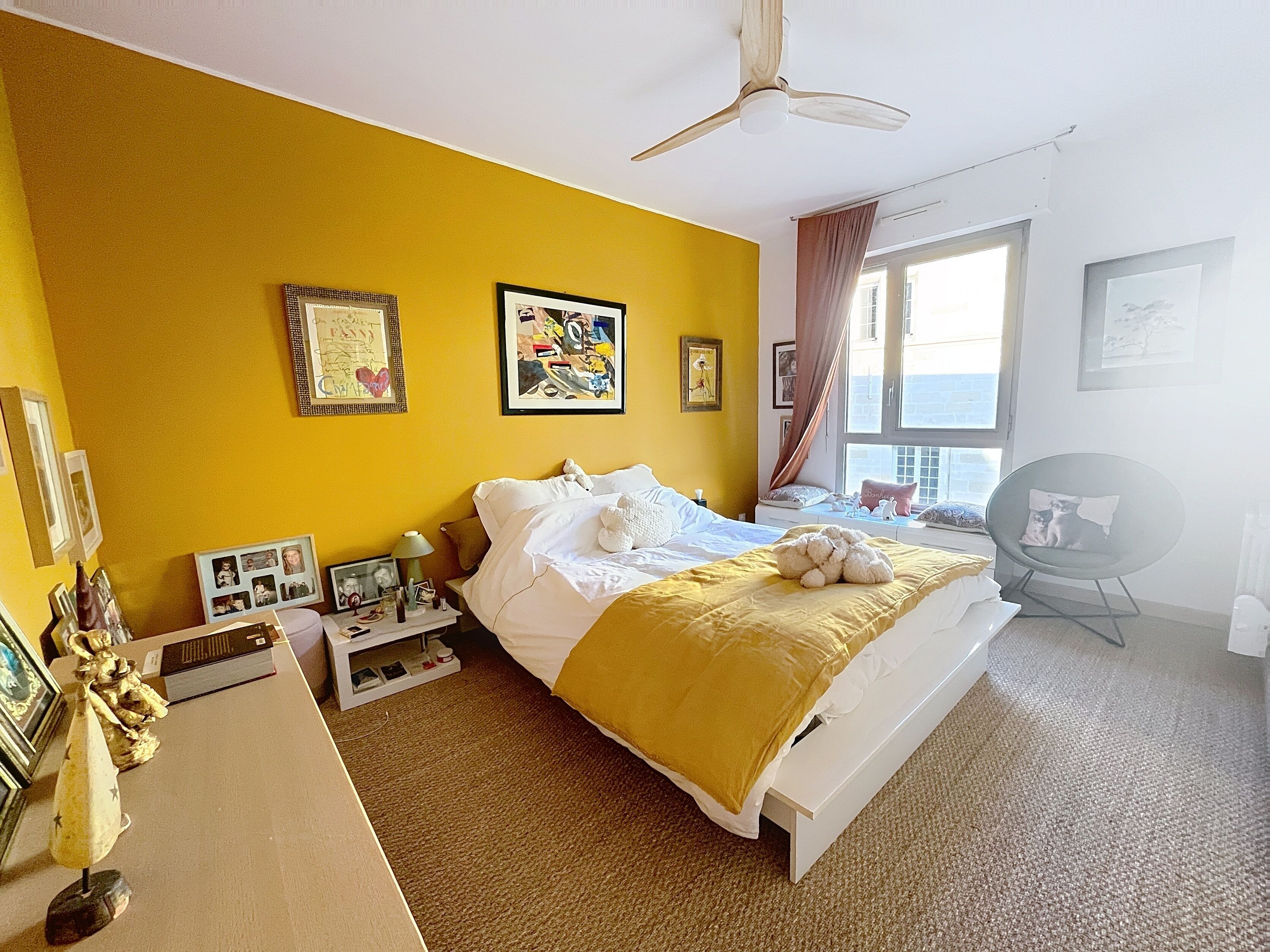 A hotel room with a bed, a desk, a chair, and a window with curtains.