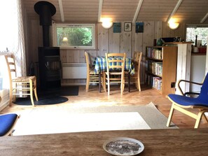 A cozy cabin interior with a fireplace, wooden furniture, and a bookshelf. - 4 Star Holiday Home in Vejby (Vejby)