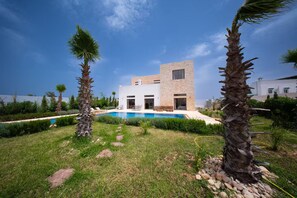 A modern two-story house with a swimming pool, surrounded by palm trees and a well-maintained lawn. - Lovely Villa 4 Bedrooms and Swimming pool (Ghazoua)