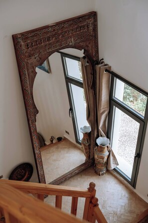 A room with a large ornate mirror, a wooden staircase, and a window with curtains. - Lovely Villa 4 Bedrooms and Swimming pool (Ghazoua)