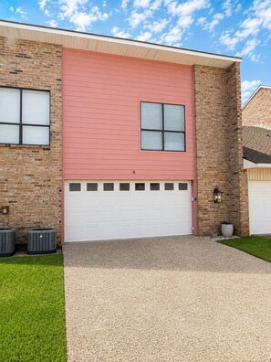 A residential building with a brick facade, a red roof, and a white garage door. - False River Waterfront Escape in Charming New Roads (New Roads)