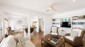 A spacious living room with a sofa, chairs, a coffee table, and a television. - False River Waterfront Escape in Charming New Roads (New Roads)