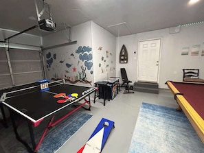 A room with a ping pong table, a pool table, and a projector mounted on the ceiling. - Hot tub, Game room, Pool, 7 miles to stockyards (Haltom City)