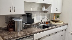 A modern kitchen with white cabinets, stainless steel appliances, and a granite countertop. - Stay Close to Everything  15 Min to Laughlin AFB (Del Rio)
