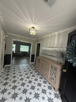 A hallway with a star-patterned floor, a wooden console with drawers, and a chandelier. - Lakefront with amazing views on beautiful Lake Hamilton in Hot Springs, Arkansas (Hot Springs)