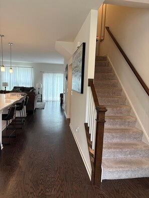 A modern interior with a staircase, a kitchen area, and a dining space. - 3-bedroom, 2.5 bath cozy new townhouse in tranquil Stafford with AC and comfort (Stafford)
