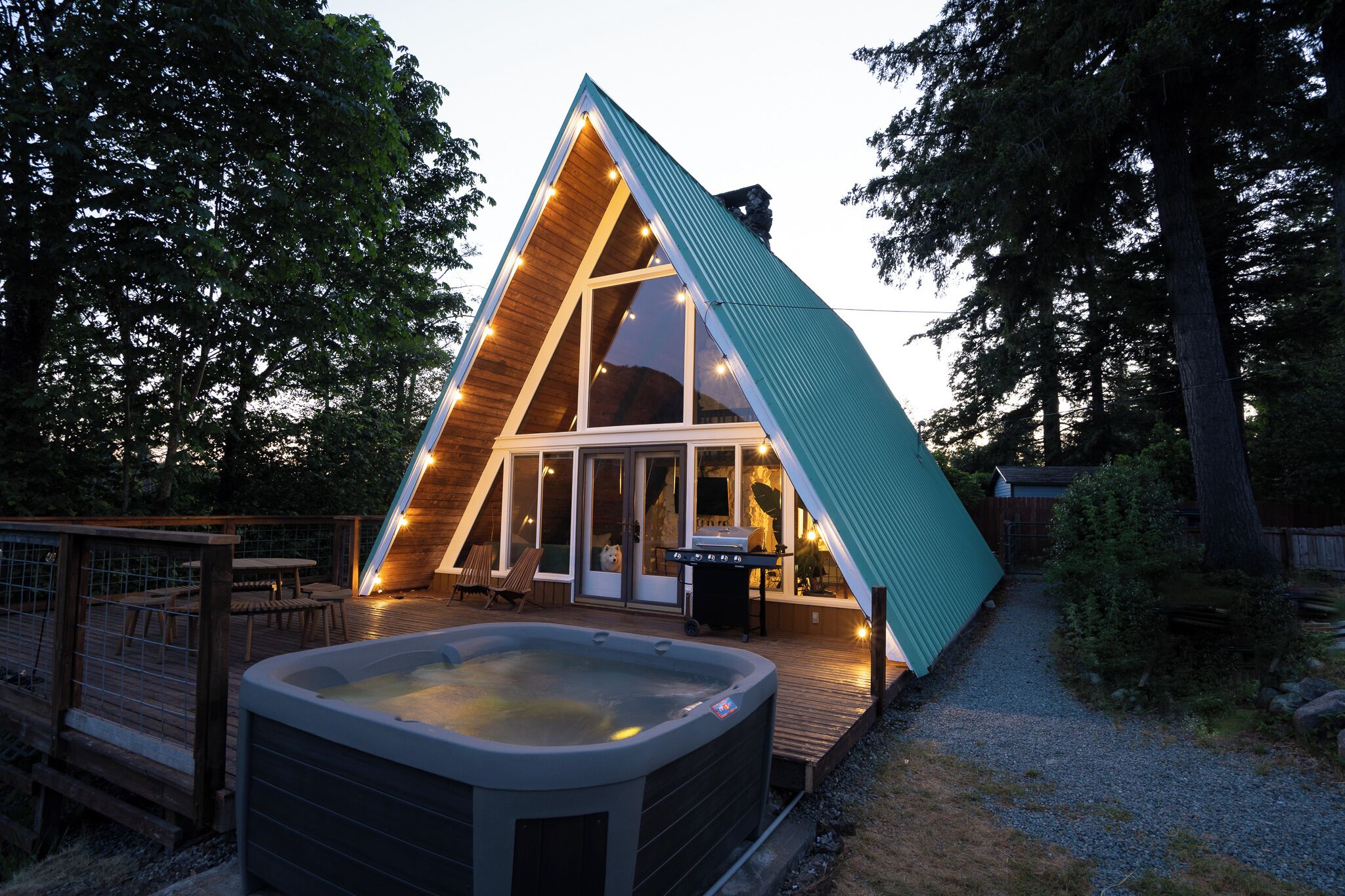 Une cabane de forme triangulaire dotée d’un bain à remous et d’une terrasse.