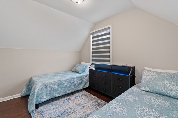 A bedroom with two beds, a dresser, and a window with blinds. - The Corner House-Annapolis (Annapolis)