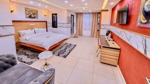 Une chambre d’hôtel moderne équipée d’un lit, d’un bureau et d’un coin salon.