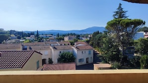 A residential area with houses, a road, and a mountain in the background. - T2 climatisé avec vue proche de Cannes et Grasse (Mouans-Sartoux)