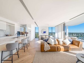 A modern living space with a kitchen, dining area, and seating area with a view. - The Arches by Aryve | Surfers Paradise (Surfers Paradise)